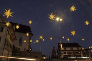Weihnachtsbeleuchtung von Essert-Illuminationen mit LED-Lichterketten und Fiberglassternen als Straßenüberspannung in Wollerau